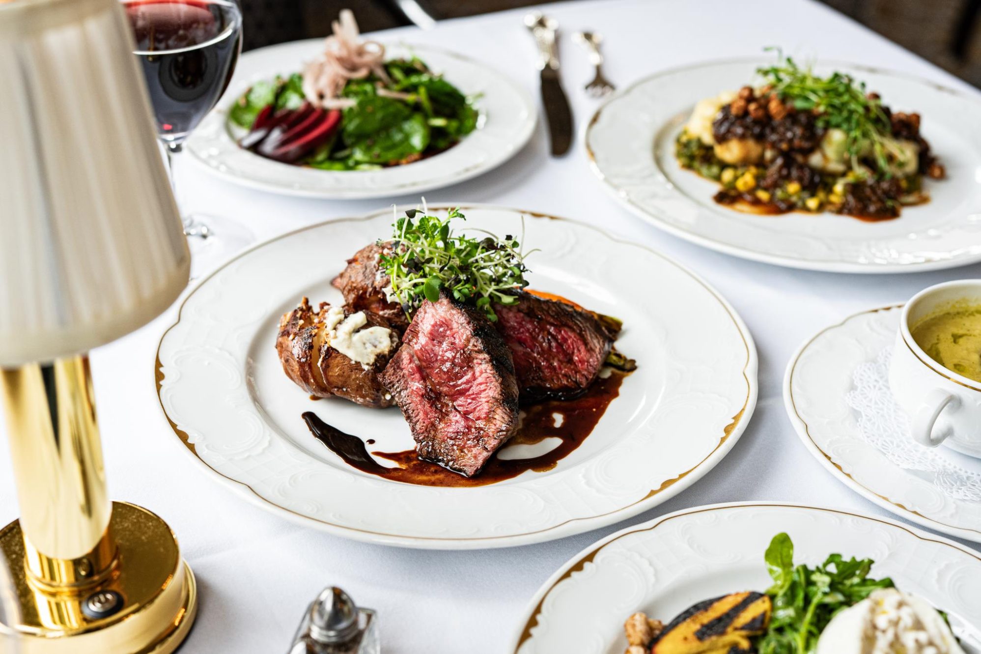 Seasonal dishes served on gold-rimmed plates in the Member dining room